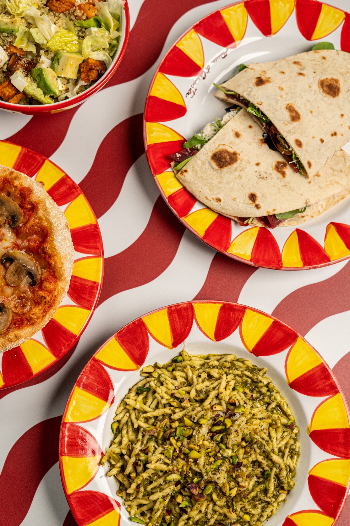 Southern Italian table spread with pasta, pizzetta, olive oil and tomatoes